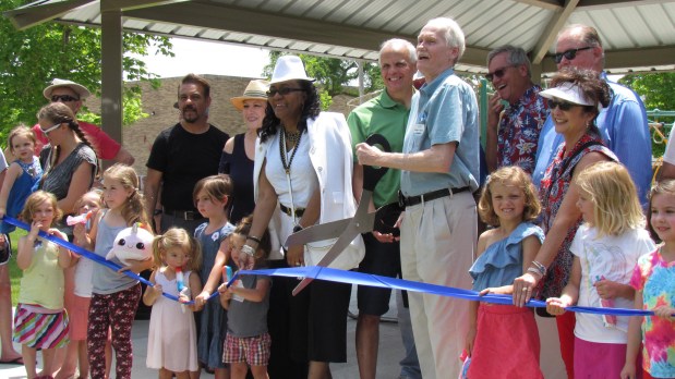 At center, Aurora Ald. Scheketa Hart-Burns, 7th Ward, and Ald. Michael Saville, 6th Ward, with scissors, cut the ribbon at a new park in Aurora in 2019. Hart-Burns, who died Monday, spent more than 32 years on the Aurora City Council.