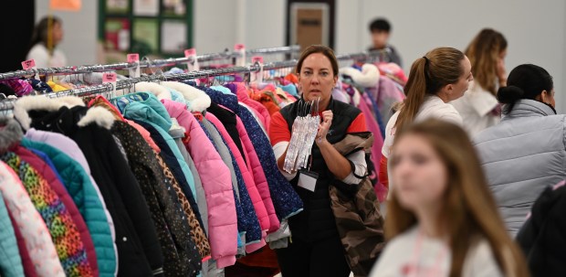 Center, carrying hangers is volunteer and Coats and Snow Pants Manager Simone Zorzy of Barrington at Barrington Giving Day's Winter Event on Dec. 14, 2024 at Station Middle School (215 Eastern Ave.) in Barrington. (Karie Angell Luc/Pioneer Press)