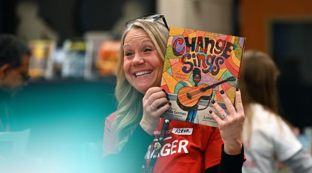 Showing a book is volunteer Robin Padal, a sixth grade English teacher at Station Middle School at Barrington Giving Day's Winter Event on Dec. 14, 2024 at Station Middle School (215 Eastern Ave.) in Barrington. (Karie Angell Luc/Pioneer Press)