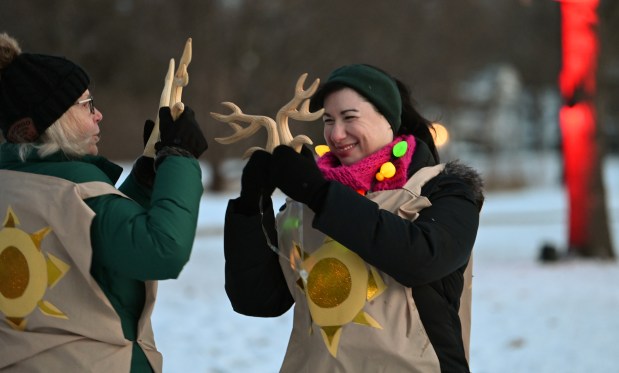 Right, Melissa Maganuco of Orlando, Florida, and of the New Trier Township High School Class of 1999, takes part in the Abbots Bromley Horn Dance at the ninth annual Winter Solstice Trail of Lights event and parade on Dec. 20, 2024 in Glencoe at Shelton Park. (Karie Angell Luc/Pioneer Press)