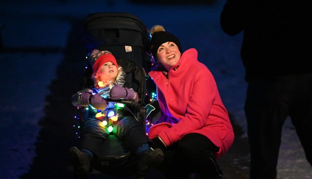 Mariah Cunnick of Winnetka and daughter Ava Scovil, 2, are on a path and waiting for the parade to begin at the ninth annual Winter Solstice Trail of Lights event and parade on Dec. 20, 2024 in Glencoe at Shelton Park. (Karie Angell Luc/Pioneer Press)