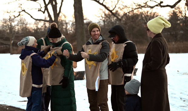 Center, smiling, Jordan Wood of Highland Park prepares with other performers for the Abbots Bromley Horn Dance at the ninth annual Winter Solstice Trail of Lights event and parade on Dec. 20, 2024 in Glencoe at Shelton Park. (Karie Angell Luc/Pioneer Press)