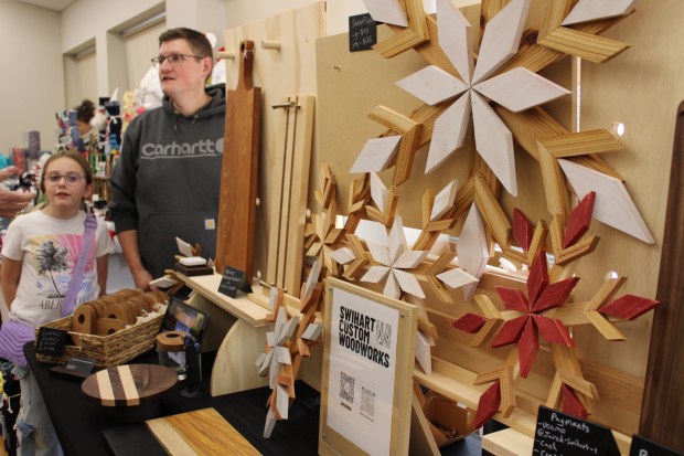 Jared Swihart and daughter Emily Swihart, 10, of Deerfield, shared hand-crafted home décor pieces created by Swihart Custom Woodworks on Saturday at the Deerfield Winter Holiday Market. (Gina Grillo/ For the Pioneer Press)