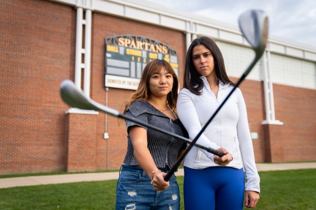 Glenbrook North High School golfers Martha Kuwahara and Alexis Myers pose for a portrait at Glenbrook North High School in Northbrook on Monday, Oct. 28, 2024. Kuwahara finished first in Class 2A at the state meet and Myers finished second, helping the Spartans to a team title too. (Audrey Richardson/for the Pioneer Press)