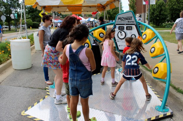 The Glenview Park District demonstrates MOVMNT a new electronic playground game that tests hand-eye coordination and that is powered by people, during Glenview Summer Fest 2024 on Saturday. (Gina Grillo for the Pioneer Press)