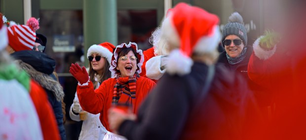 Mrs. Claus cheers on Rotary Santa Run participants as they pass the start line on Campbell Street on Dec. 7, 2024 in downtown Arlington Heights. (Karie Angell Luc/Pioneer Press)