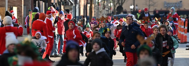 Participants of a wave of the Reindeer Dash make their way to the Campbell Street finish line on Dec. 7, 2024 in downtown Arlington Heights. (Karie Angell Luc/Pioneer Press)