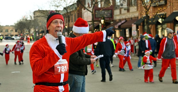 Arlington Heights Mayor Thomas Hayes addresses the start line audience before the race/walk on Campbell Street on Dec. 7, 2024 in downtown Arlington Heights. (Karie Angell Luc/Pioneer Press)