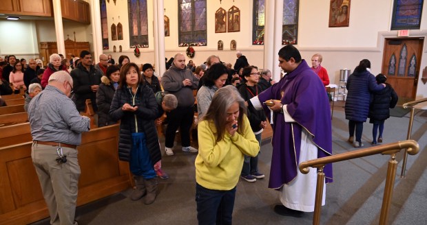 Right, Rev. Anthony Castello offers communion for Simbang Gabi 2024 on Dec. 16, 2024 at Saints Peter and Lambert Parish (St. Peter Chapel) in Skokie. (Karie Angell Luc/Pioneer Press)