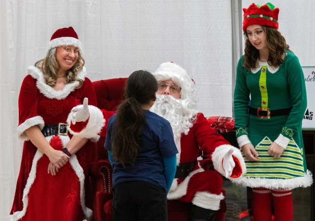 Santa Claus, center, hugs a child as Mrs. Claus and an elf look on during the Boys & Girls Clubs of NWI's "A Christmas to Remember" on Thursday, Dec. 6, 2024 at the Dean and Barbara White Community Center in Merrillville. (Michael Gard/for the Post-Tribune)