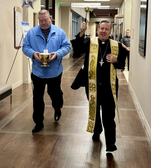 The Most Rev. Robert J. McClory, Bishop of the Diocese of Gary, sprinkles holy water during a blessing of the new St. Mary Medical Center Emergency Department in Valparaiso, which opened Dec. 1. He is assisted by Deacon Michael Halas, a chaplain with Powers Health. (Photo courtesy of Powers Health)