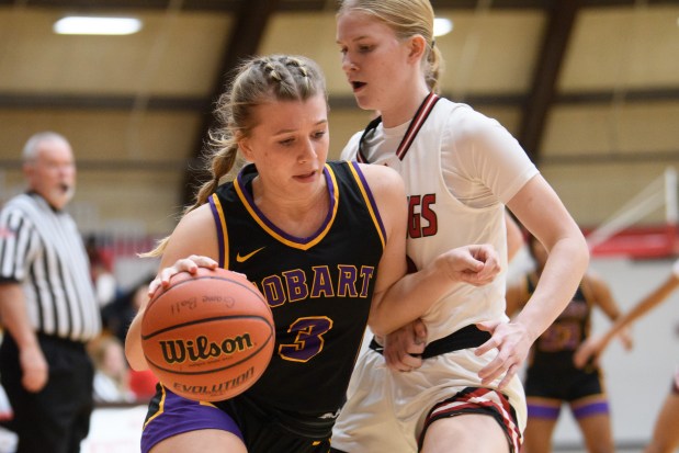 Hobart's Ladan Weinman drives to the basket past Munster's Cecilia Mason during their Northwest Crossroads Conference game on Tuesday, Nov. 26, 2024. (Kyle Telechan/for the Post-Tribune)