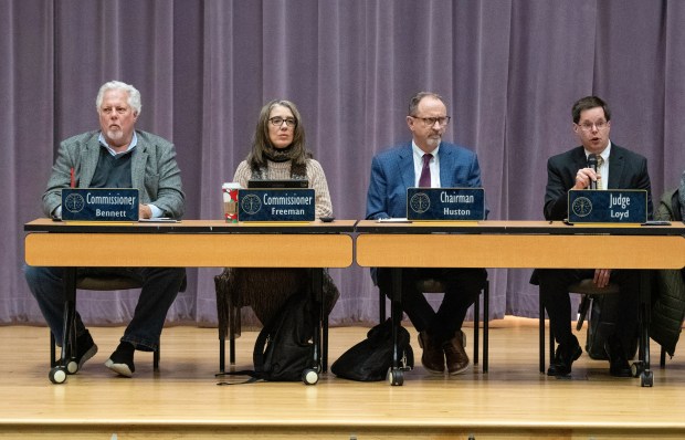 Members of the Indiana Utility Regulatory Commission, from left, commissioner Wesley R. Bennett, commissioner Sarah Freeman, chairman Jim Huston and judge Greg Loyd attend a public hearing about proposed electric rate hikes for NIPSCO customers on Tuesday, Nov. 26, 2024 at Ivy Tech Community College in Valparaiso. (Michael Gard/for the Post-Tribune)