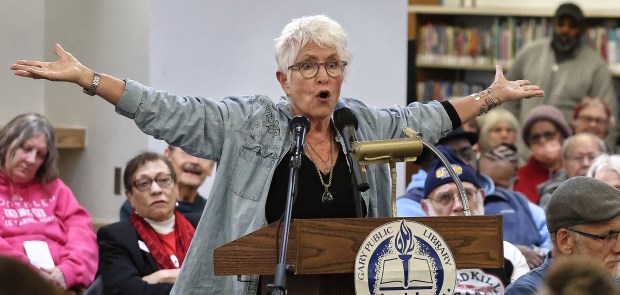 Christine Kysel tells the panel of the 10 million gallons of coal ash that has poisoned her well in Porter County during the Indiana Utility Regulatory Commission hearing on NIPSCO's proposed 20% rate increase, which would drive up residential customers' monthly bills around $45 per month. The meeting took place at the Woodson Branch Library in Gary on Thursday, Dec. 5, 2024. (John Smierciak / Post Tribune)