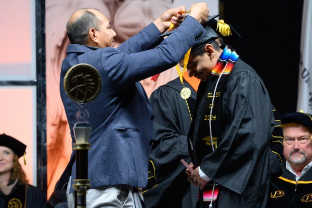 College of Technology graduate Anthony Vazquez is presented a chancellor medallion by his father, Jose Vazquez, during Purdue Northwest's afternoon commencement ceremony in Hammond on Saturday, Dec. 14, 2024. (Kyle Telechan/for the Post-Tribune)