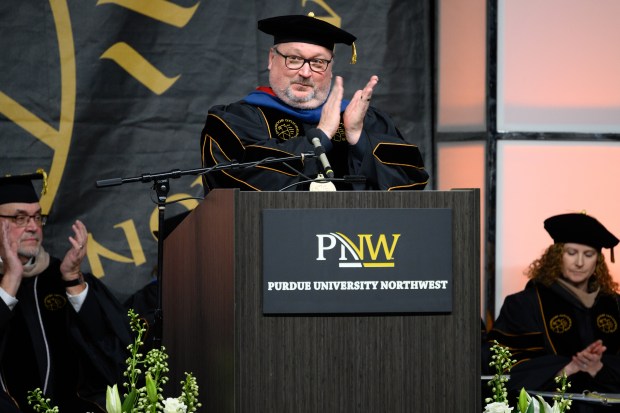 Purdue University Northwest chancellor Kenneth C. Holford applauds for students during the school's afternoon commencement ceremony in Hammond on Saturday, Dec. 14, 2024. (Kyle Telechan/for the Post-Tribune)