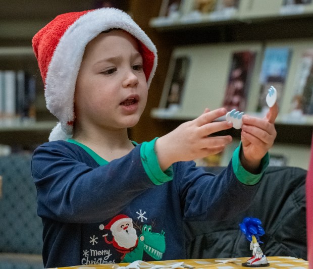 Four-year-old Rowan French makes a Yeti ornament during the Winter Wonder Fest celebration at the Portage Public Library in Portage, Indiana, on Friday Dec. 20, 2024.(Andy Lavalley/for the Post-Tribune)