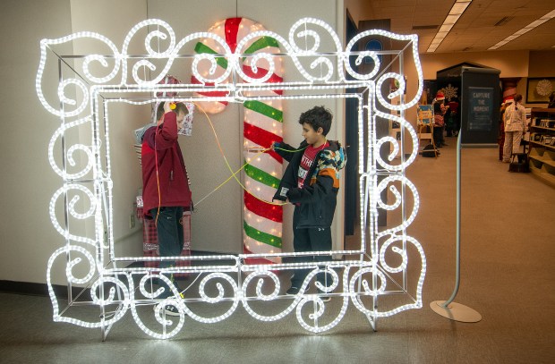 Rafi Mediona, left, tries to untangle with his brother Xavi during the Winter Wonder Fest celebration at the Portage Public Library in Portage, Indiana, on Friday Dec. 20, 2024. (Andy Lavalley/for the Post-Tribune)