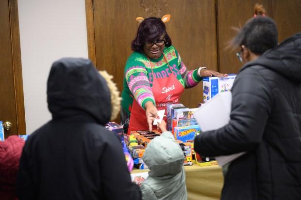 Volunteer Debra Davis takes a ticket to exchange for a free gift during the 36th annual Spirit of Christmas gift giveaway in Gary on Monday, Dec. 23, 2024. (Kyle Telechan/for the Post-Tribune)