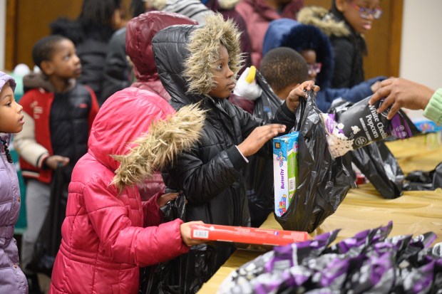 Children are given gifts, popcorn, and candy as part of the 36th annual Spirit of Christmas gift giveaway in Gary on Monday, Dec. 23, 2024. (Kyle Telechan/for the Post-Tribune)