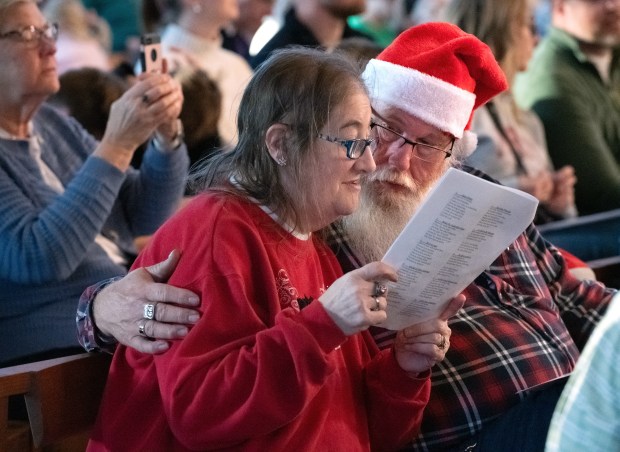 Jim Ashford looks on as his wife Dottie sings a holiday carol during the annual TubaChristmas at Valparaiso University concert held in the Chapel of the Resurrection at Valparaiso University in Valparaiso, Indiana, on Sunday, Dec. 8, 2024. The couple live in South Haven, Indiana, and have been married for 40 years.(Andy Lavalley/for the Post-Tribune)