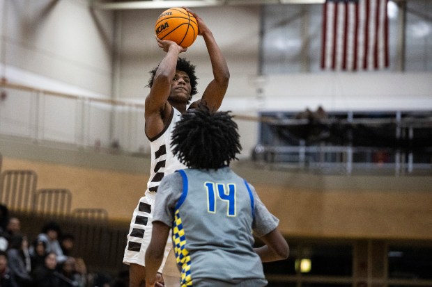 Mount Carmel's Cameron Thomas puts up a shot over De La Salle's Charles Barnes (14) during a Chicago Catholic League Blue game in Chicago on Friday, Dec. 13, 2024. (Vincent D. Johnson / for the Daily Southtown)