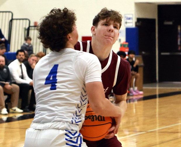 Lockport's Collin Miller, right, and Lincoln-Way East's Evan Riiff, left, fight for the ball during the basketball game in Frankfort on Friday, Dec.12, 2024. (James C. Svehla / for the Daily Southtown)