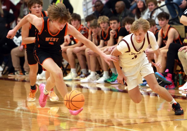 Lincoln-Way West's Luke Gouty and Lockport's' Nedas Venckus chase a the loose ball during the basketball game in Lockport on Friday, Dec. 6, 2024. (James C. Svehla / for the Daily Southtown)