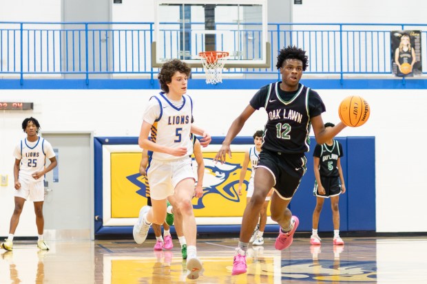 Oak Lawn's Marc Harvey (12) dribbles down court against Lyons during a game in the Sandburg Shot Clock Shootout in Orland Park on Saturday, Dec. 21, 2024. (Troy Stolt / for the Daily Southtown)