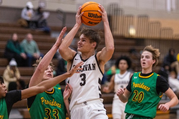 Mount Carmel's Grant Best (3) goes to the basket over Providence's Luke Rost (33) during a Catholic League crossover game in Chicago on Tuesday, Dec. 10, 2024. (Vincent D. Johnson / for the Daily Southtown)