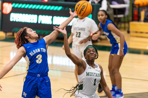 Bloom Township's Sinaee Price (3) reach out for a rebound over Evergreen Park's Brianna Uwajeh (1) during a nonconference game in Evergreen Park on Tuesday, Dec. 17, 2024. (Vincent D. Johnson / for the Daily Southtown)