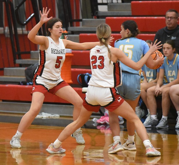 Marist's Lucy Cosme (5) and Olivia Barsch (23) double team Joliet Catholic's Allison Lesters (15) during an East Suburban Catholic Conference game Monday, Dec. 2, 2024 in Chicago, IL. (Steve Johnston/for the Daily Southtown)