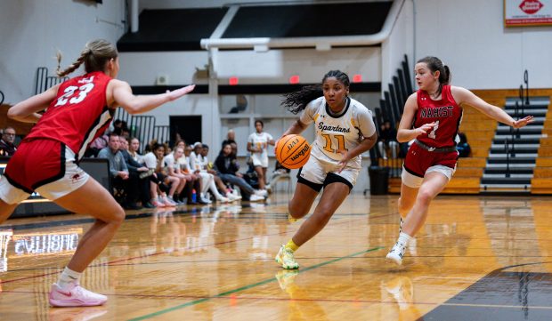 Marian Catholic's Alainna Poisson (11) drives up the court during a game against Marist on Wednesday, Dec. 11, 2024, at Marian Catholic High School in Chicago Heights, Ill. (Vincent Alban / Daily Southtown)