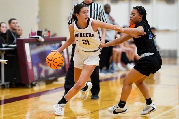 Lockport's Katie Peetz (21) brings the ball up the court against Sandburg's Makaleigh Terry (23) during a basketball game at Lockport High School on Monday, Dec. 16, 2024. (Sean King / for The Daily Southtown)