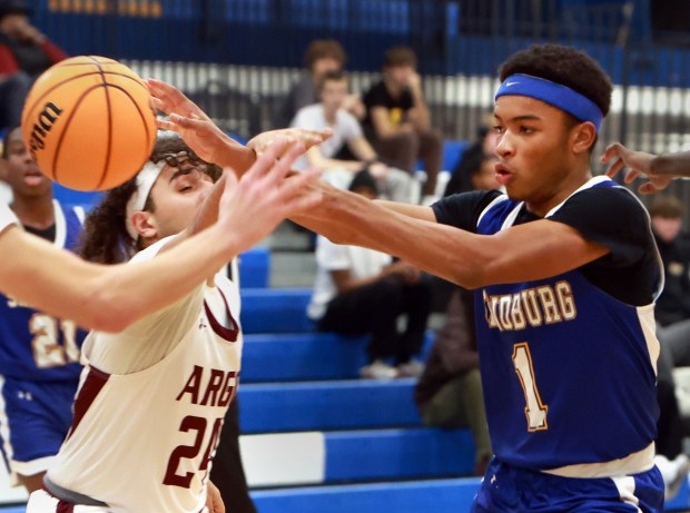 Sandburg's Malachi Perkins, right, passes the ball as Argo's Kassam Saleh defends during the Maine East Holiday Tournament in Park Ridge on Friday, Dec. 27, 2024. (James C. Svehla / for the Daily Southtown)