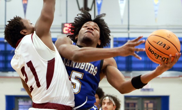 Sandburg's Jonah Johnson, right, goes for the net as Argo's Jayvon King, left, defends during the Maine East Holiday Tournament in Park Ridge on Friday, Dec. 27, 2024. (James C. Svehla / for the Daily Southtown)