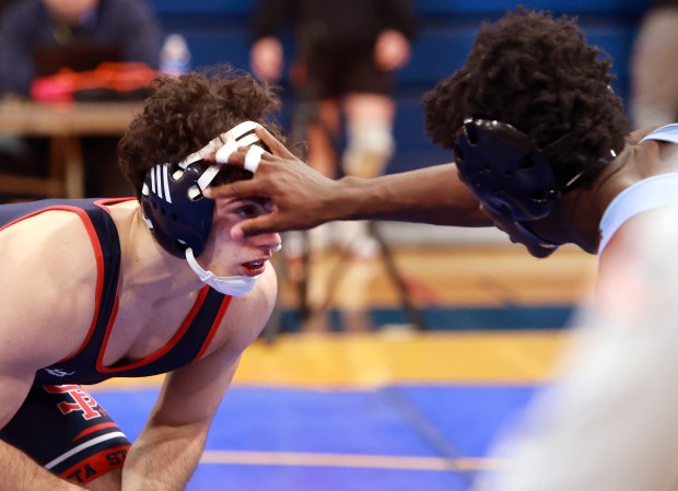 St Rita's Enzo Canali, left, and Belleville East's Dewayne Taylor during the 144 weight class McLaughlin Classic wrestling meet at Joliet Central High School in Joliet on Saturday, Dec. 7, 2024. (James C. Svehla / for the Daily Southtown)