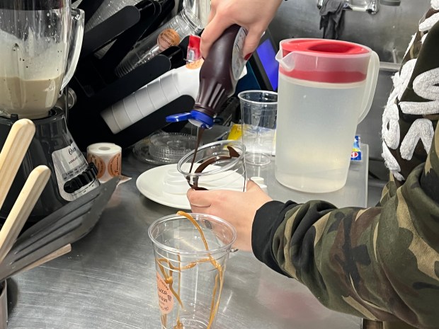 Lizbeth Guzman-Fonseca makes protein shakes Dec. 12, 2024, for guests at her store in Harvey. All of her food offerings are made with sugar-free ingredients, she said. (Samantha Moilanen/Daily Southtown)