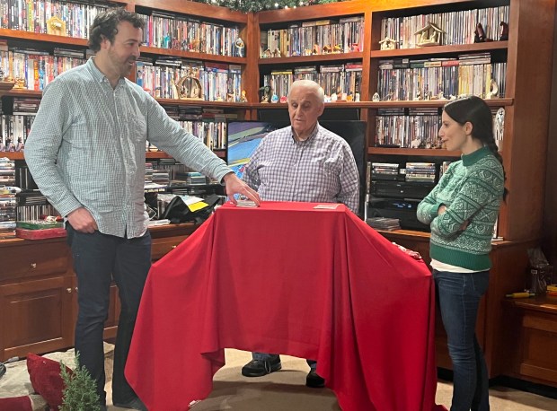 Magician Ron Centanni, center, performs a card trick for niece Leah Riha, right, and her husband, Andrew Riha, while visiting relatives in California. Centanni is a member of Magic Masters of Chicago. (Ray Centanni)