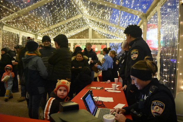 New Lenox police Officer Kristine Kioltyka helps give Liz Lyons an ID card Nov. 30, 2024. The Police Department operates a children's ID program annually at the Christmas on the Common event, part novelty and part safety feature. (Jesse Wright/for the Daily Southtown)