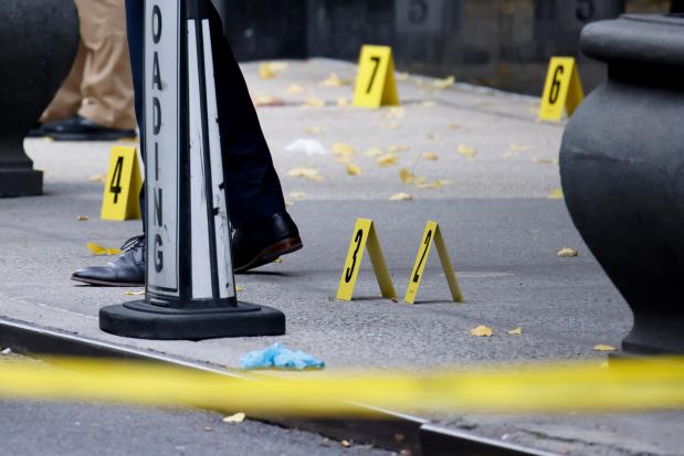 Members of the New York police crime scene unit investigate bullets lying on the sidewalk at the scene outside the Hilton Hotel in midtown Manhattan where Brian Thompson, the CEO of UnitedHealthcare, was fatally shot, Wednesday, Dec. 4, 2024, in New York. (AP Photo/Stefan Jeremiah)