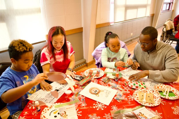 Lucas Herard, from left, Kathy Herard, Kara Herard, and Ludwig Herard, do arts and crafts while waiting for breakfast and pictures with Santa and Mrs. Claus at the annual "Breakfast with Santa" event December 7, 2024 at Lincolnwood Community Center in Lincolnwood. (Kaitlin Mikrut/for Pioneer Press)