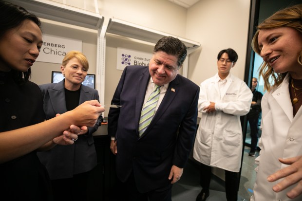 Dr. Priscilla Chan, left, Dr. Shana Kelley, president of Chan Zuckerberg Biohub Chicago, Gov. JB Pritzker, and Hope Burks, far right, also from CZ Biohub Chicago, examine an instrumental human tissue model for researching skin on Oct. 5, 2023, in Chicago. (Vincent D. Johnson/for the Chicago Tribune)