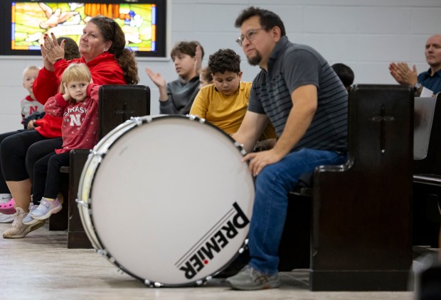 A child covers her ears while a large drum is used during a Mass held for deaf parishioners, Oct. 13, 2024, at St. Francis Borgia. (Brian Cassella/Chicago Tribune)