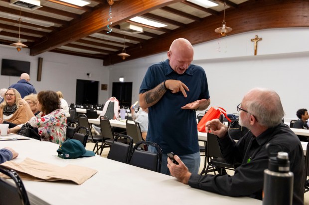 Danny Rosasco socializes with other members after a Mass held for deaf parishioners, Oct. 13, 2024, at St. Francis Borgia. (Brian Cassella/Chicago Tribune)