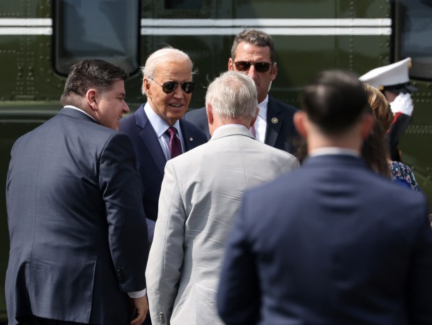 President Joe Biden is greeted by Gov. JB Pritzker, left, U.S. Sen. Dick Durbin, center right, and other government leaders upon his arrival south of Soldier Field for the Democratic National Convention at the United Center on Aug. 19, 2024. (John J. Kim/Chicago Tribune)