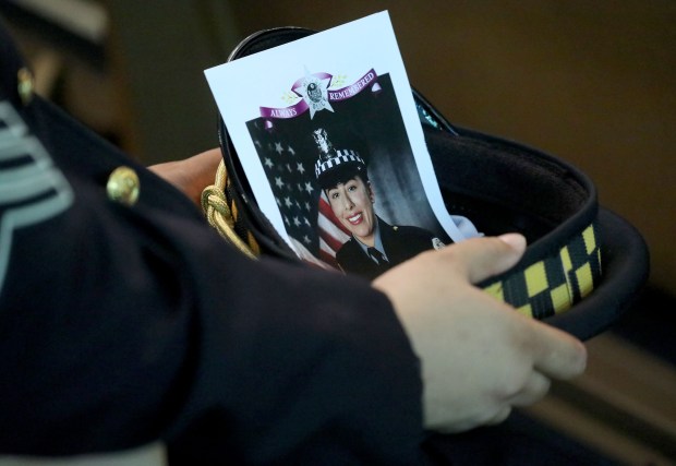 A police officer with the image of fellow Officer Ella French in his hat at the funeral service for French on Aug. 19, 2021, at St. Rita of Cascia Shrine Chapel. French was fatally shot Aug. 7 and her partner was seriously wounded after a traffic stop in the West Englewood neighborhood. (Antonio Perez/Chicago Tribune)