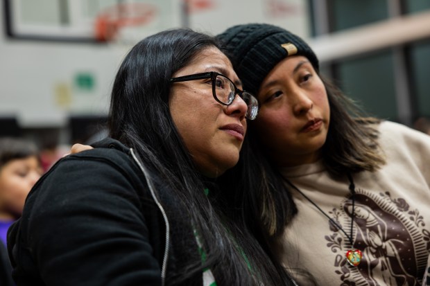 Acero Schools Carlos Fuentes Elementary parents Angelica Juarez, left, and best friend Eva Molinero, right, listen as people speak out against the closure of seven of Acero Schools Charter Network's 15 local schools during public comment at an Acero Schools Board of Directors meeting at Idar Elementary in the Gage Park neighborhood of Chicago on Dec. 11, 2024. (Tess Crowley/Chicago Tribune)