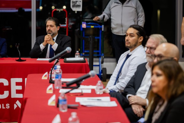 President and CEO of Acero Schools Richard Rodriguez, left, and board members, right, listen as people speak out against the closure of seven schools during public comment at an Acero Schools Board of Directors meeting at Idar Elementary on Dec. 11, 2024. (Tess Crowley/Chicago Tribune)