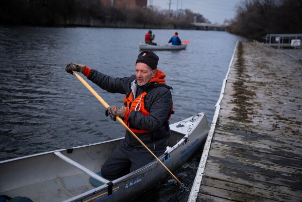 Canoe guide Marvin Fournier puts a canoe in the North Branch of the Chicago River at the Clark Park boat launch on Dec. 19, 2024. (E. Jason Wambsgans/Chicago Tribune)